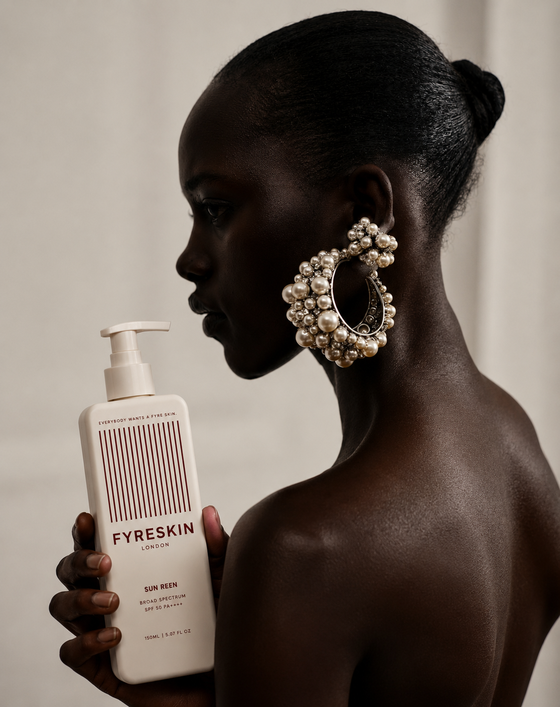 FYRE SKIN Sun Reen SPF 50 bottle held by a model